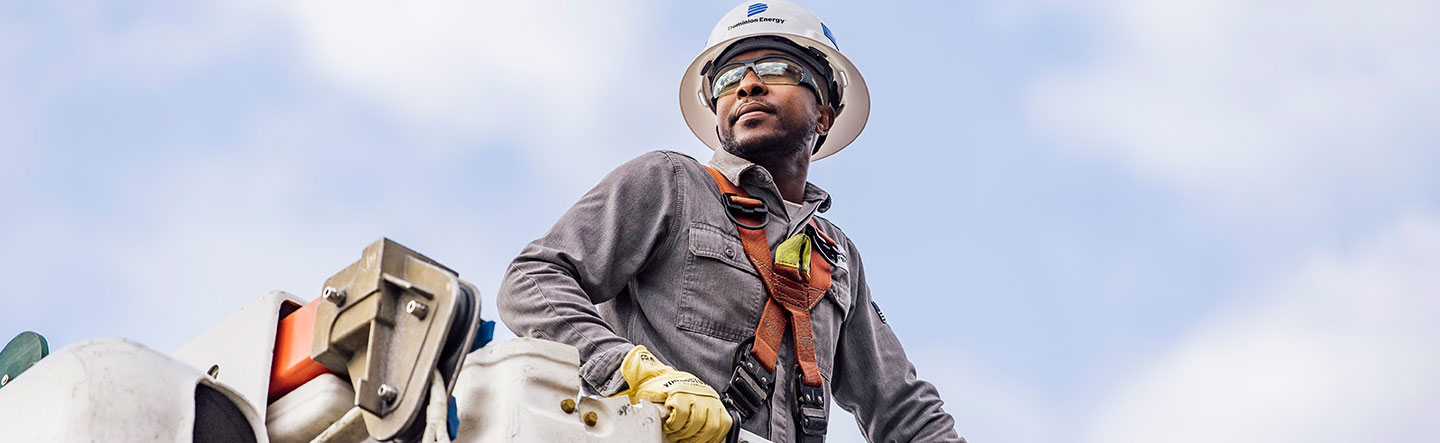 Lineman in bucket before a blue sky
