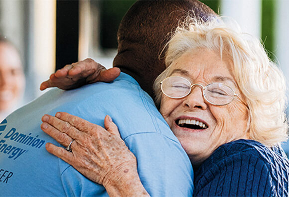Dominion Energy Employee Volunteer Hugging Customer