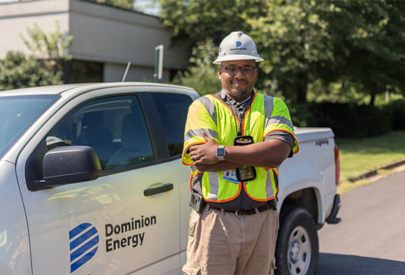 Dominion Energy Employee Standing in Front of Company Vehicle