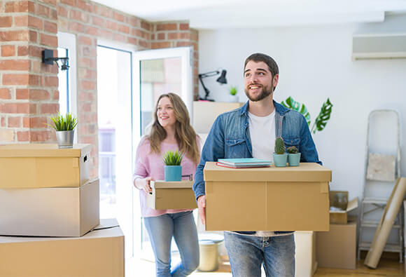 Couple Moving Boxes Into New Home