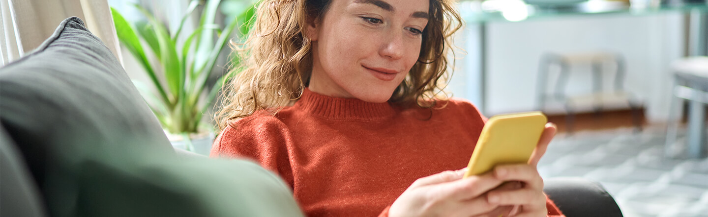 Lady Sitting on Couch on Mobile Phone