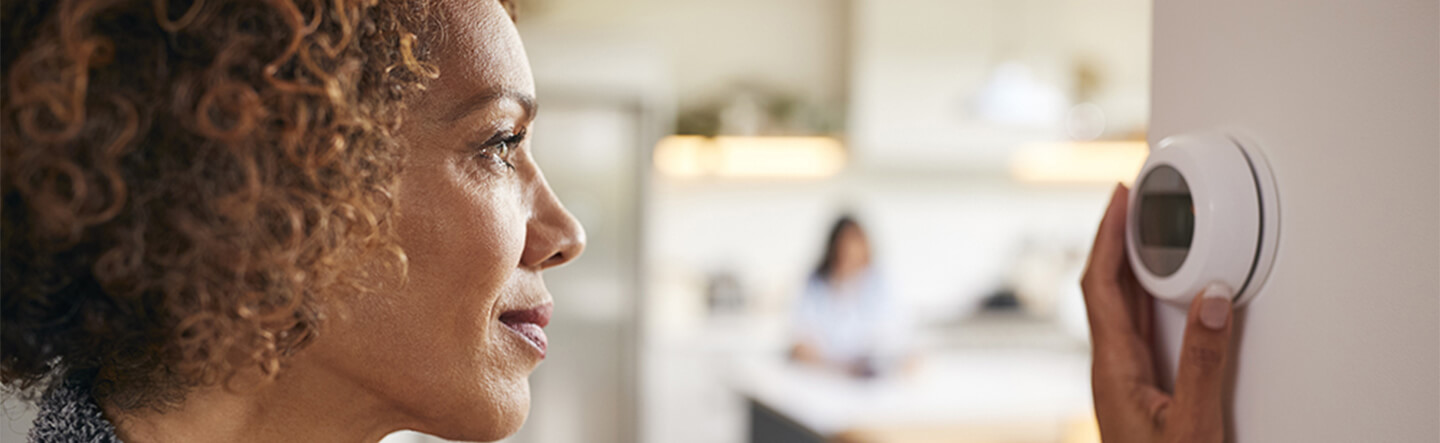 Lady Adjusting Smart Thermostat