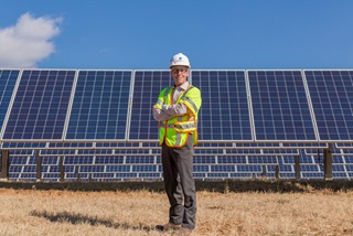 Employee in front of solar panels
